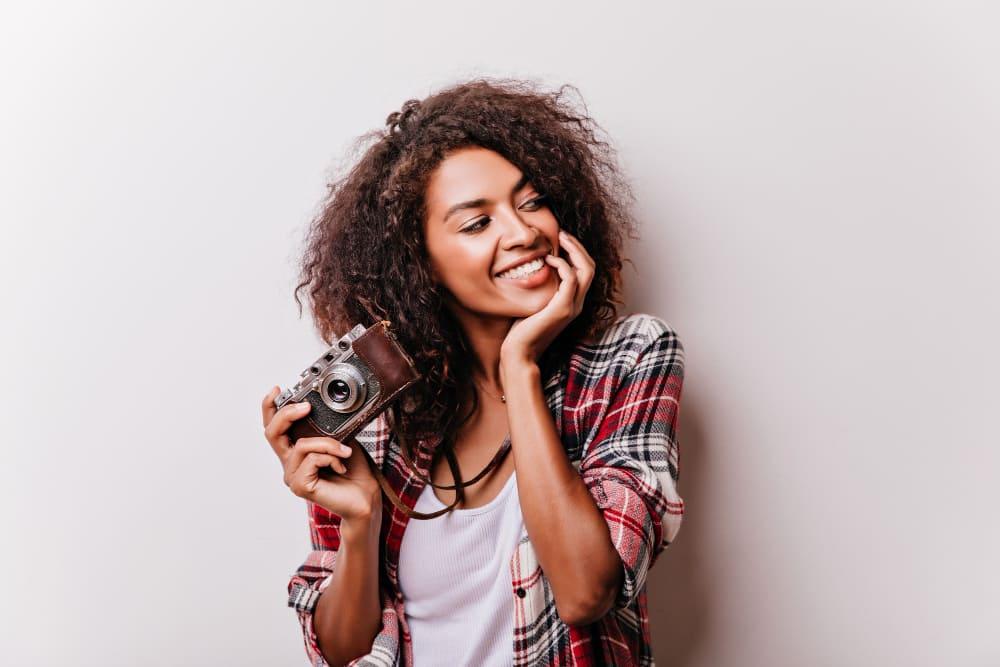 Photo of a smiling woman holding a camera 